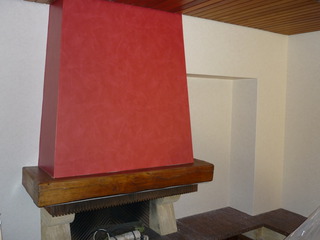 Wohnzimmer mit Kamin und rot tapezierter Schornsteinwand – modernes Tapezieren als stilvoller Akzent im Raum.